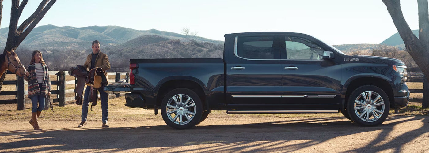 man throwing saddle in pickup truck